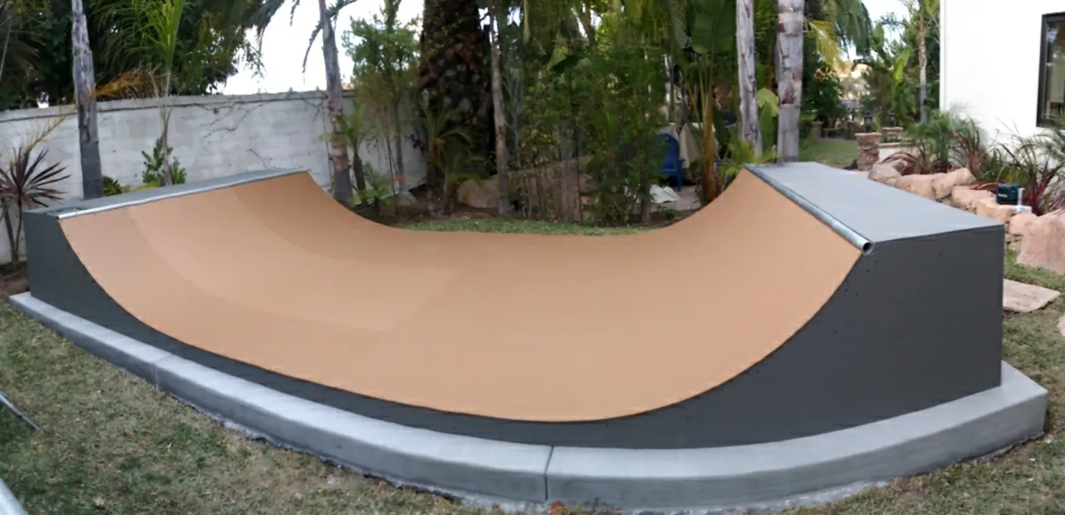 Two and a half foot high miniramp in backyard on foundation footer blocks near wall