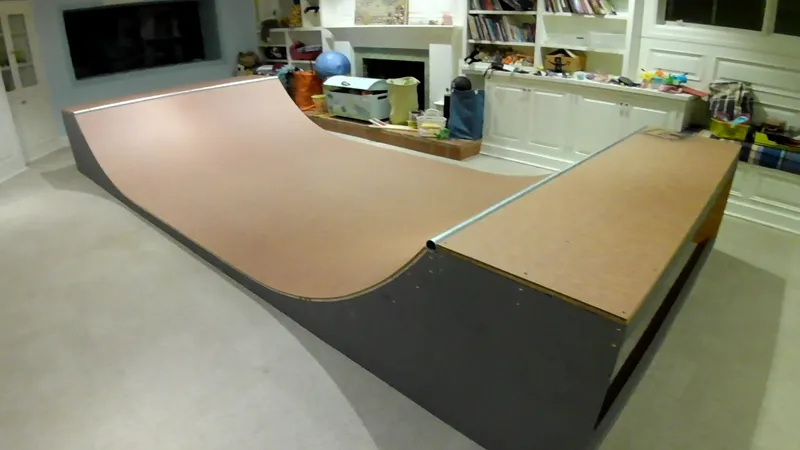 Two and a half foot high miniramp in basement room with a TV