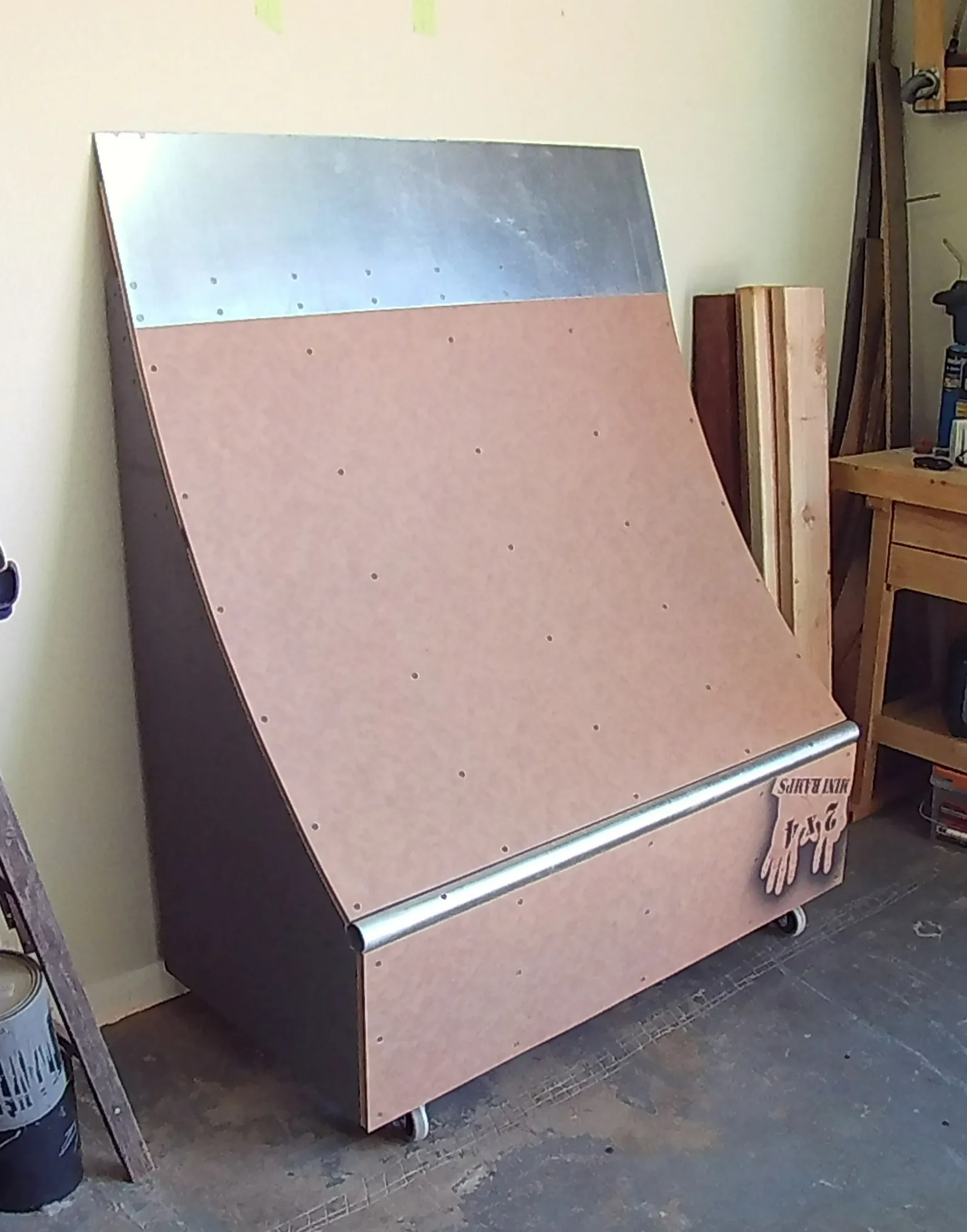 Two foot high by four foot wide quarter pipe on wheels up against a wall