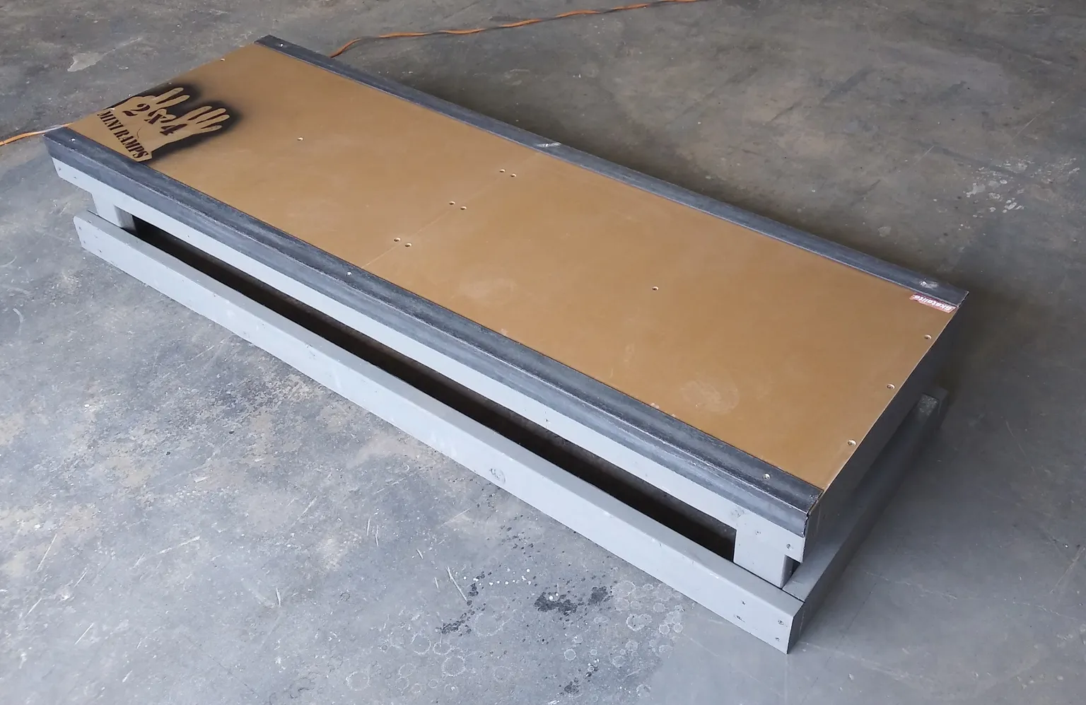 One foot high by six foot long grind box on concrete, side view