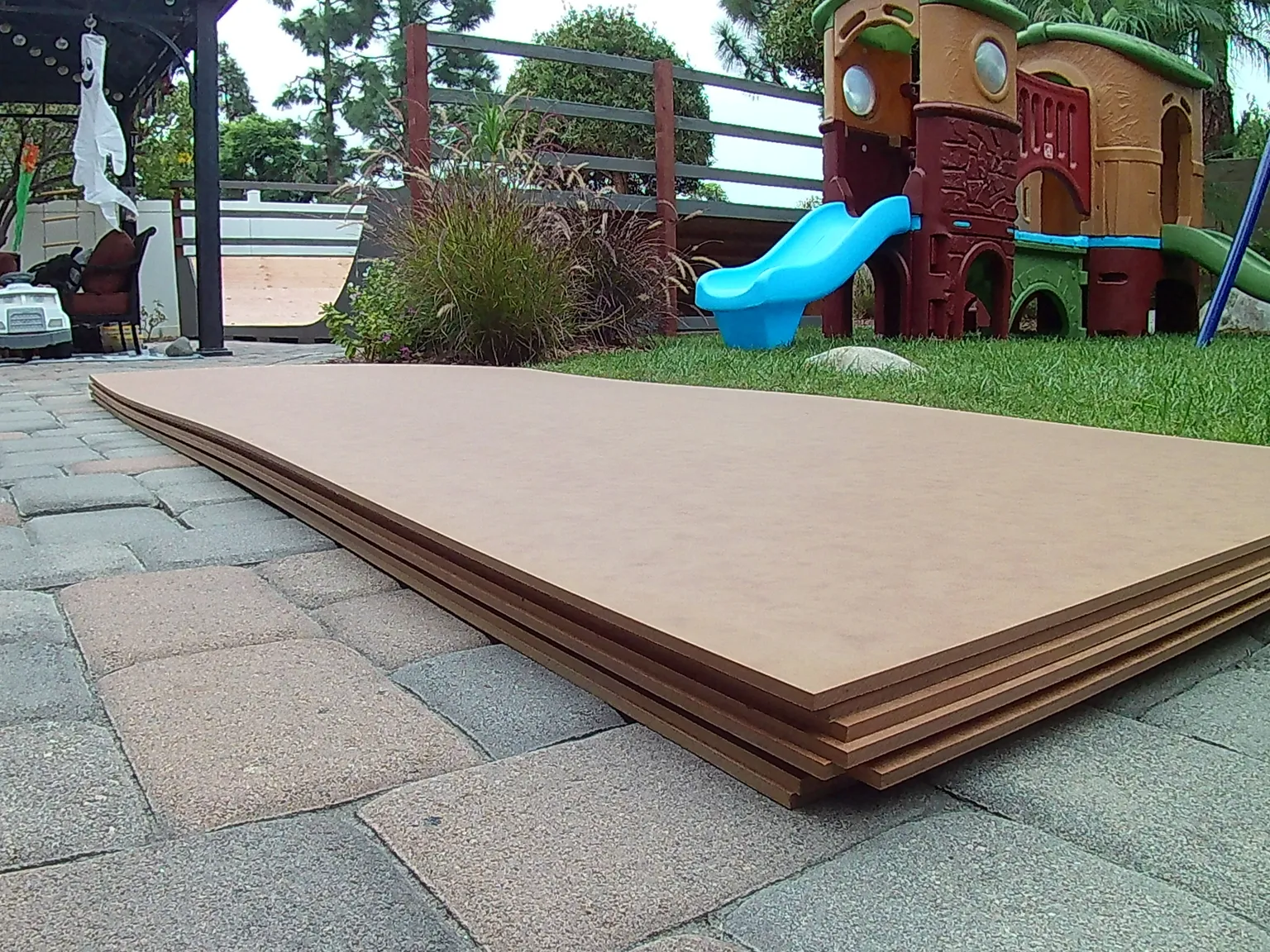 A pile of around 8 sheets of Gator Skins ramp surface stacked on patio